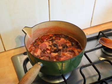 Meyveli bir tava reçel yapmak için kaynatılıyor.