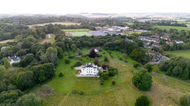 An aerial drone so if you of an old country house set in rolling countryside in the summer clipart