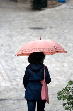 Mallorca 'da yağmurlu bir gün nedeniyle şemsiyeli ve sıcak elbiseli insanlar. 10 Kasım 2022.