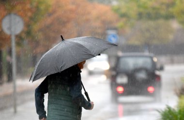 Mallorca 'da yağmurlu bir gün nedeniyle şemsiyeli ve sıcak elbiseli insanlar. 10 Kasım 2022.