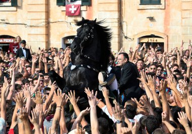 Ciudadela, Menorca, İspanya 'da Sant Joan şenlikleri. 23 ve 24 Haziran 'da düzenlenirler ve binicilerin ve onların yerli Menorcan atlarının yer aldığı farklı etkinliklerden oluşurlar..