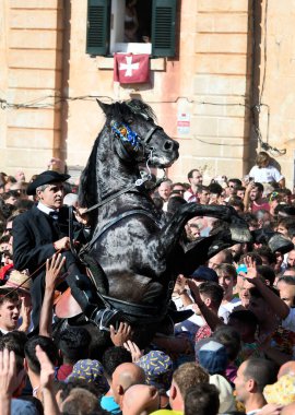 Ciudadela, Menorca, İspanya 'da Sant Joan şenlikleri. 23 ve 24 Haziran 'da düzenlenirler ve binicilerin ve onların yerli Menorcan atlarının yer aldığı farklı etkinliklerden oluşurlar..