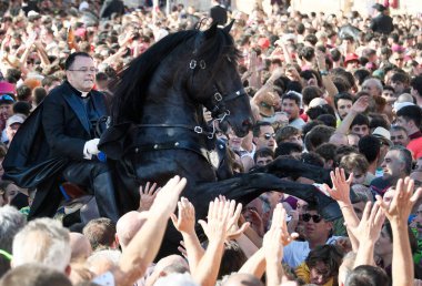 Ciudadela, Menorca, İspanya 'da Sant Joan şenlikleri. 23 ve 24 Haziran 'da düzenlenirler ve binicilerin ve onların yerli Menorcan atlarının yer aldığı farklı etkinliklerden oluşurlar..