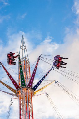 Karnaval lunaparkında gökyüzü salıncağı. Açık hava, akşam, gün batımı, İngiltere