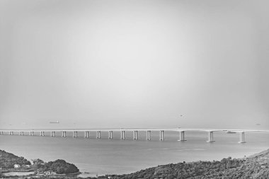 Efsanevi Hong Kong-Zhuhai-Macao Köprüsü 'nün siyah-beyaz fotoğrafı, Lantau Adası dağ tarafından görülüyor.