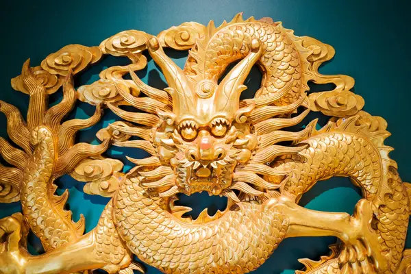 Golden sculpture of the Traditional Chinese Dragon, majestic creature, in a green background