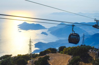 Babadag 'da harika bir gün batımı. Teleferik teleferikleri dağın zirvesine ulaşmak için kullanılır. Fethiye, Mugla, Türkiye