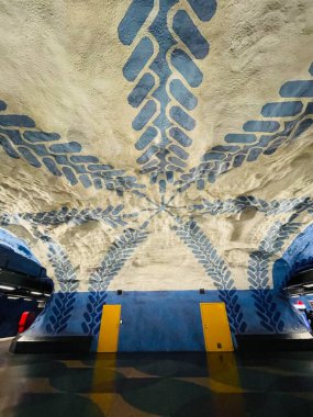 Stockholm, İsveç 'teki metro istasyonunda. Kayadan, yürüyen merdivenden, duvarlarda ve tavanda mavi tasarım tablolardan yapılmış metro istasyonu..