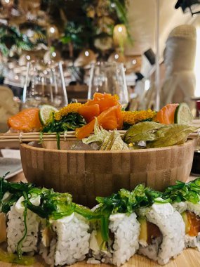 Suşi ruloları, nigiri, maki, turşu zencefil, wasabi, soya sosu ahşap tabakta ve yeşil ağaç arka planında. Japon deniz ürünleri. Yiyecek konsepti. 