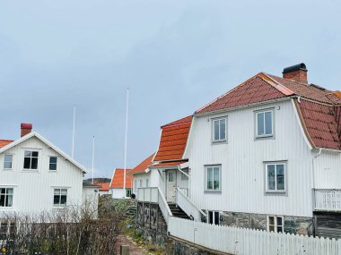 Vrango, Güney Göteborg Takımadası, İsveç - 8 Nisan 2022: Vrango, Güney Göteborg Takımadası, Bulutlu Gökyüzü 'nde beyaz ahşap evleri olan bir köy manzarası. 