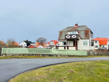 Vrango, Güney Göteborg Takımadası, İsveç - 8 Nisan 2022: Vrango, Güney Göteborg Takımadası, Bulutlu Gökyüzü 'nde beyaz ahşap evleri olan bir köy manzarası. 