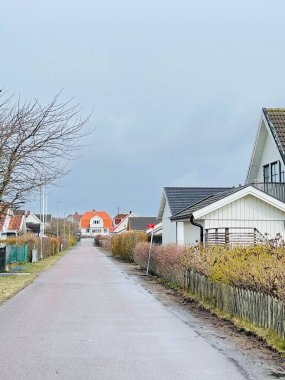 Vrango, Güney Göteborg Takımadası, İsveç - 8 Nisan 2022: Vrango, Güney Göteborg Takımadası, Bulutlu Gökyüzü 'nde beyaz ahşap evleri olan bir köy manzarası. 