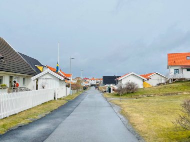 Vrango, Güney Göteborg Takımadası, İsveç - 8 Nisan 2022: Vrango, Güney Göteborg Takımadası, Bulutlu Gökyüzü 'nde beyaz ahşap evleri olan bir köy manzarası. 