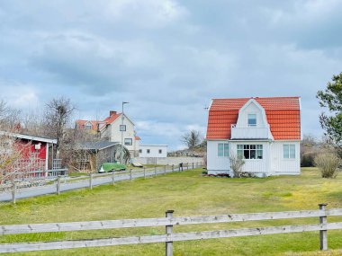 Vrango, Güney Göteborg Takımadası, İsveç - 8 Nisan 2022: Vrango, Güney Göteborg Takımadası, Bulutlu Gökyüzü üzerinde ahşap evleri olan bir köy manzarası. 