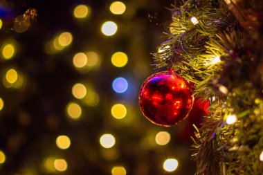 Topları Noel ağacına yakın tut. Bokeh geçmişi. Yeni yıl konsepti. Boşluğu kopyala