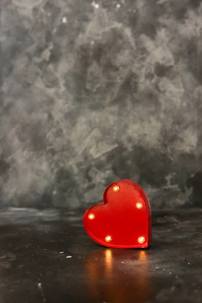 Red lighted heart on a black bacground. Copy space. Valentine concept.