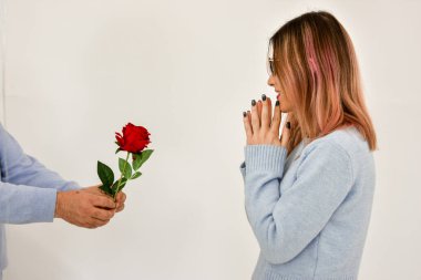 Man giving a red rose and surprised woman isolated on white background. . Copy space, valentine , birthday card concept.