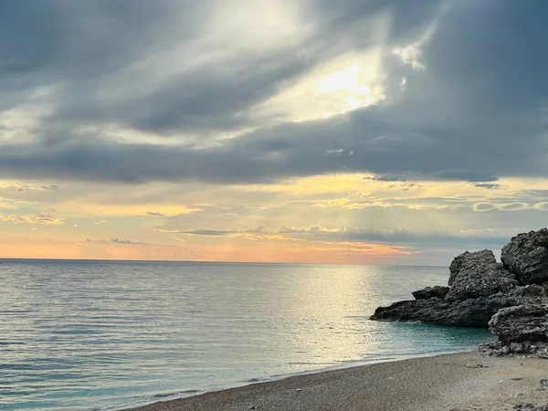 Vlore Arnavutluk 'taki İoninan Denizi üzerinde günbatımı manzarası. Sakin dalgalarla dalgalanan güzel bir su. Yatay fotoğraf. Boşluğu kopyala.
