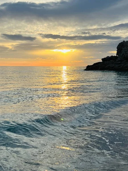 Vlore Arnavutluk 'taki İoninan Denizi üzerinde günbatımı manzarası. Sakin dalgalarla dalgalanan güzel bir su. Dikey fotoğraf. Boşluğu kopyala.