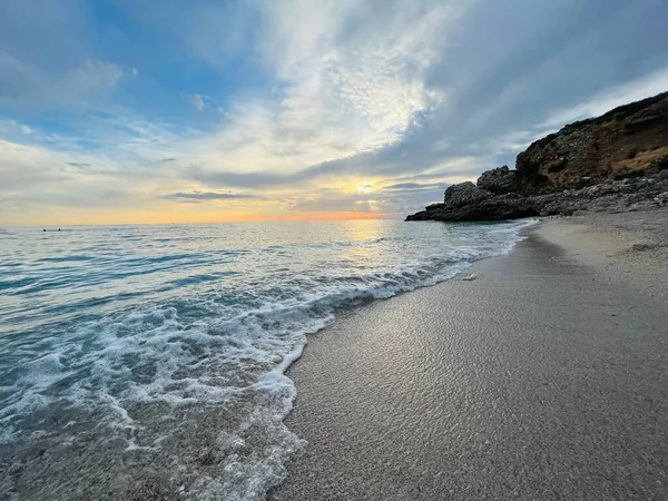 Vlore Arnavutluk 'taki İoninan Denizi üzerinde günbatımı manzarası. Sakin dalgalarla dalgalanan güzel bir su. Yatay fotoğraf. Boşluğu kopyala.