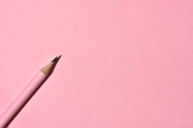 High Angle View of sharp wooden pencil on pink background. Education and school concept. Copy space. Selective focus.