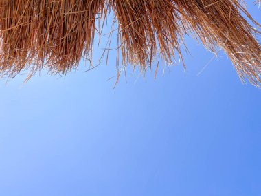 Arnavutluk 'taki İyon plajında açık mavi gökyüzü olan saman plajı şemsiyesi, Vlore. Boşluğu kopyala