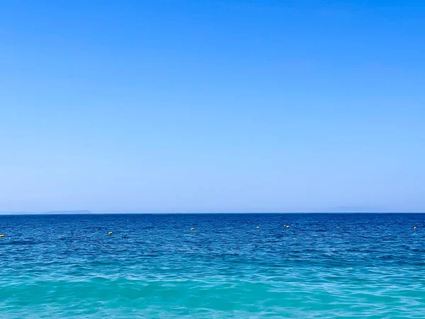 アルバニアのイオニア海のロッキービーチとクリスタルターコイズブルーの水 夏休みのコンセプト コピースペース 横写真 — ストック写真
