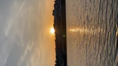 Gün batımında, gün doğumunda, göl yüzeyine yansıyan güneş ışığı. 4 K videosu. Dikey video. Yüksek kaliteli FullHD görüntüler