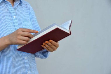 Elinde kitabı tutan genç bir kadın, mesaj için yeri var. Okul günü konsepti.