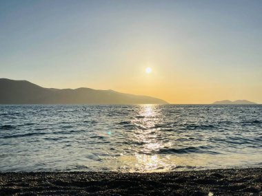 Vlore Arnavutluk 'taki İoninan Denizi üzerinde günbatımı manzarası. Sakin dalgalarla dalgalanan güzel bir su. Yatay fotoğraf. Boşluğu kopyala.