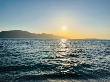 Vlore Arnavutluk 'taki İoninan Denizi üzerinde günbatımı manzarası. Sakin dalgalarla dalgalanan güzel bir su. Yatay fotoğraf. Boşluğu kopyala.