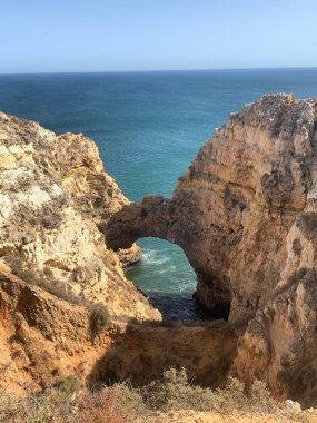Praia do Camilo sahilindeki Rocky sahili Algarve, Lagos yakınlarındaki uçurumlar arasında. dikey resim. 