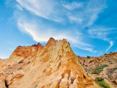 Fırtınalı bir denizden yükselen mağaraları olan yüksek kireçtaşı kayalıkları. Algar Seco, Carvoeiro Güney Portekiz, Algarve. Sahildeki kumtaşından resif oluşumu. Yatay fotoğraf. Boşluğu kopyala.
