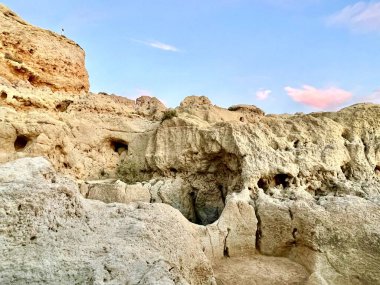 Fırtınalı bir denizden yükselen mağaraları olan yüksek kireçtaşı kayalıkları. Algar Seco, Carvoeiro Güney Portekiz, Algarve. Sahildeki kumtaşından resif oluşumu. Yatay fotoğraf. Boşluğu kopyala.