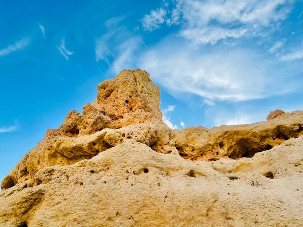 Fırtınalı bir denizden yükselen mağaraları olan yüksek kireçtaşı kayalıkları. Algar Seco, Carvoeiro Güney Portekiz, Algarve. Sahildeki kumtaşından resif oluşumu. Yatay fotoğraf. 