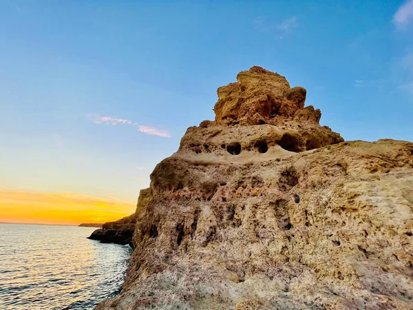 Fırtınalı bir denizden yükselen mağaraları olan yüksek kireçtaşı kayalıkları. Algar Seco, Carvoeiro Güney Portekiz, Algarve. Sahildeki kumtaşından resif oluşumu. Yatay fotoğraf. Boşluğu kopyala.