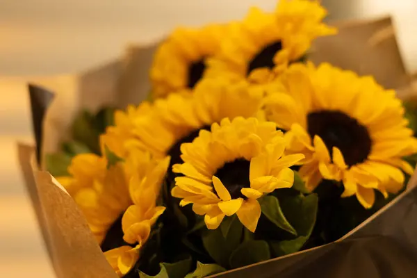 A beautiful bouquet of sunflowers stands in a vase . Bouquet for birthday , wedding ,in rustic style. copy space. Selective focus . Horizontal photo.
