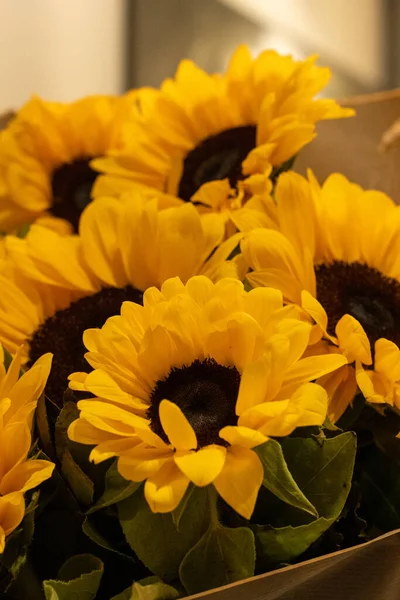 A beautiful bouquet of sunflowers stands in a vase . Bouquet for birthday , wedding ,in rustic style. copy space. Selective focus . Vertical photo.