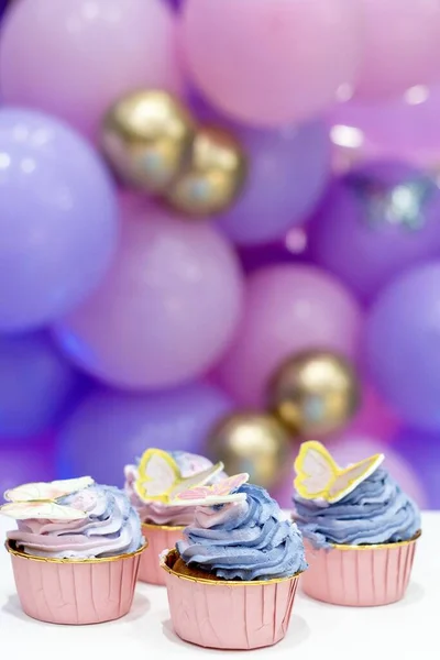 Birthday Cupcake vanilla cupcakes with pink and blue cream, selective focus, close up. copy space . Vertical photo. Birthday concept.