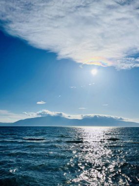 Vlore Arnavutluk 'taki İoninan Denizi üzerinde günbatımı manzarası. Sakin dalgalarla dalgalanan güzel bir su. Dikey fotoğraf. Uzayı kopyala Yaz tatili kavramı. 