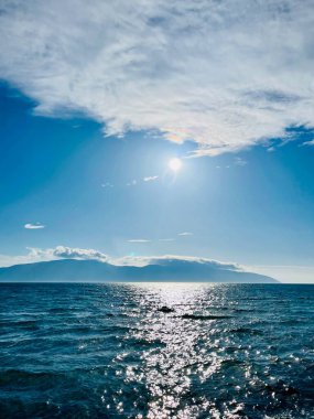 Vlore Arnavutluk 'taki İoninan Denizi üzerinde günbatımı manzarası. Sakin dalgalarla dalgalanan güzel bir su. Dikey fotoğraf. Uzayı kopyala Yaz tatili kavramı. 