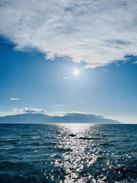 Vlore Arnavutluk 'taki İoninan Denizi üzerinde günbatımı manzarası. Sakin dalgalarla dalgalanan güzel bir su. Dikey fotoğraf. Uzayı kopyala Yaz tatili kavramı. 
