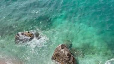 Arnavutluk 'taki Rocky plajı ve İyon Denizi' nin kristal turkuaz suyu. Çiçeklerle sakin ve rahatlatıcı bir manzara. Yaz tatili konsepti. Uzayı kopyala Yatay Yüksek Kaliteli FullHD görüntüleri