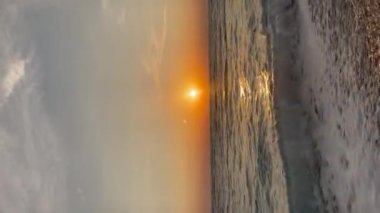 Gün batımında kumlu sahilde dalgaların gökyüzüne doğru aktığı manzara. Yüksek kaliteli FullHD görüntüler. 4K video