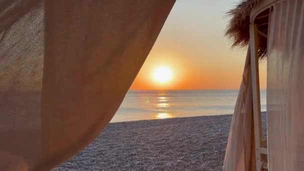 ホワイト ビーチ キャノピー リゾートで豪華なビーチテント ビーチホリデーコンセプト 日没の間 砂浜に急行する波の風景 ビデオ — ストック動画