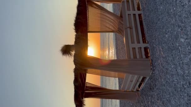 ホワイト ビーチ キャノピー リゾートで豪華なビーチテント ビーチホリデーコンセプト 日没の間 砂浜に急行する波の風景 ビデオ バーティカル — ストック動画