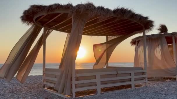 ホワイト ビーチ キャノピー リゾートで豪華なビーチテント ビーチホリデーコンセプト 日没の間 砂浜に急行する波の風景 ビデオ — ストック動画