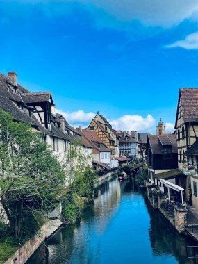 Colmar, Fransa - 01 Nisan 2024: Alsace kentsel ortaçağ manzarası, su kanalı ve Fransa 'nın Colmar kentindeki geleneksel ağaçlandırılmış evler. Dikey fotoğraf .