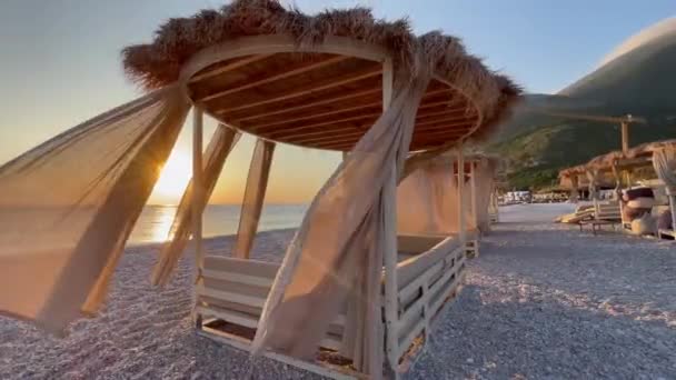 ホワイト ビーチ キャノピー リゾートで豪華なビーチテント ビーチホリデーコンセプト 日没の間 砂浜に急行する波の風景 ビデオ ビデオ — ストック動画