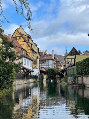 Alsace kentsel ortaçağ manzarası, su kanalı ve Fransa 'nın Colmar kentinde bulunan geleneksel yarı keresteli evler. Seyahat konsepti. Dikey Fotoğraf .